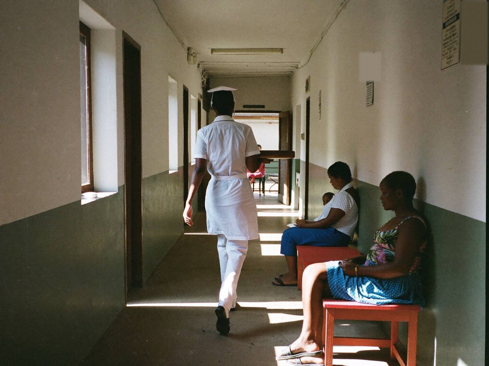 Nurse walking through a clean rural health facility corridor